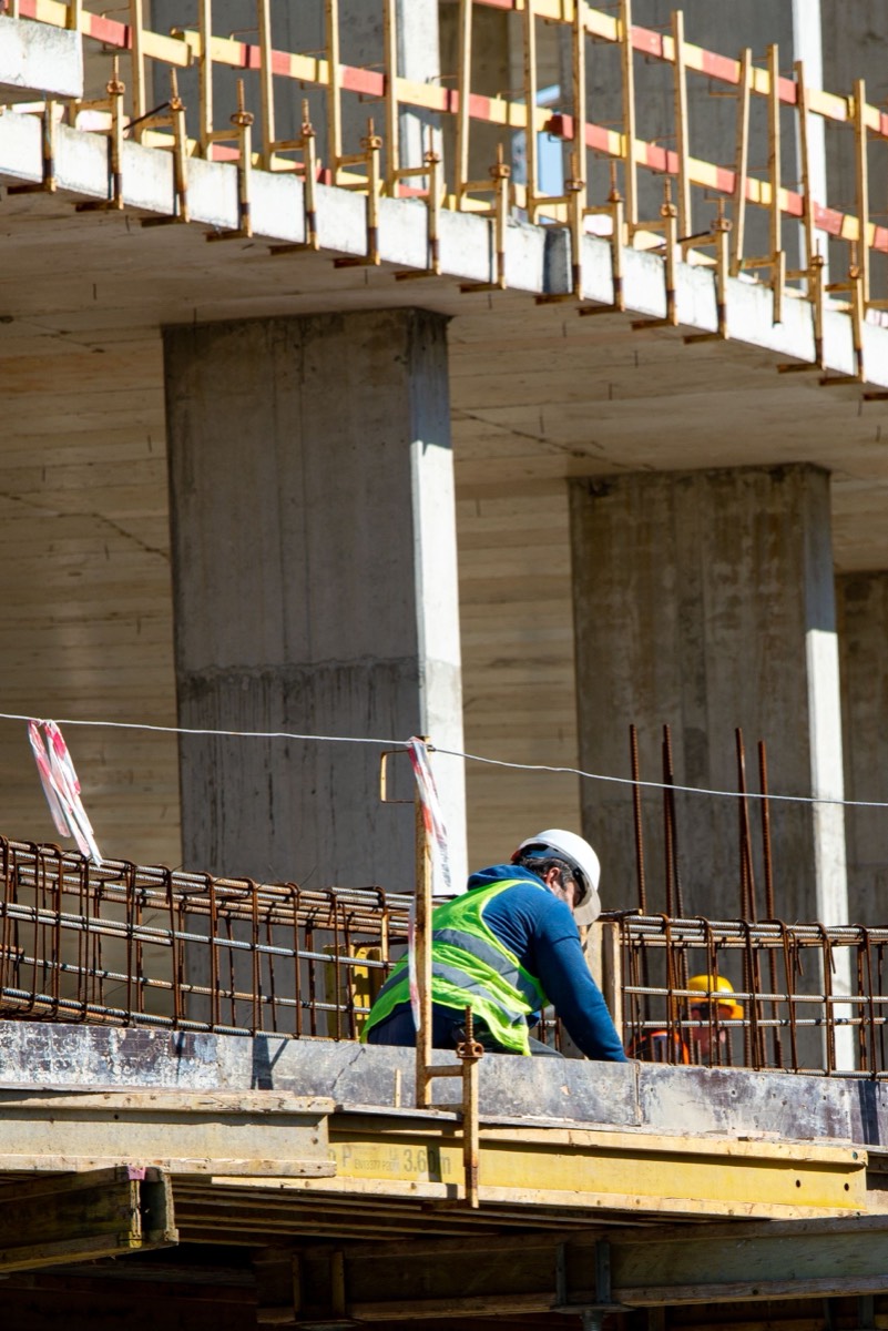 A contractor in a hard hat and safety vest on a job site